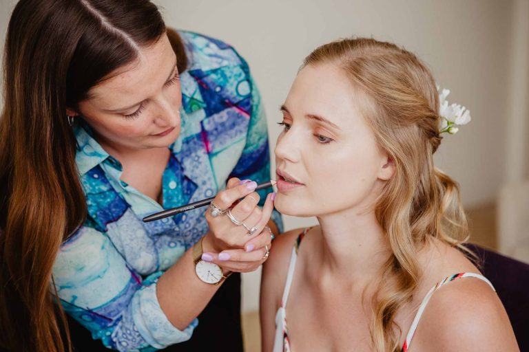 bride having makeup done on wedding morning