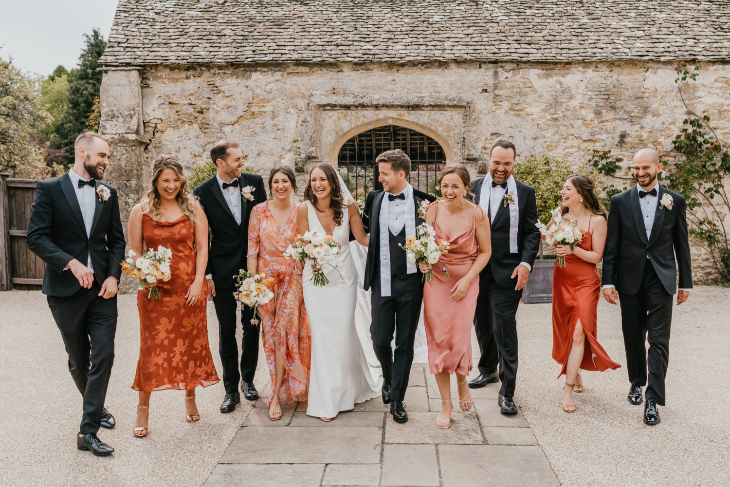 bridal party walking towards the camera with natural laughter at caswell house wedding venue