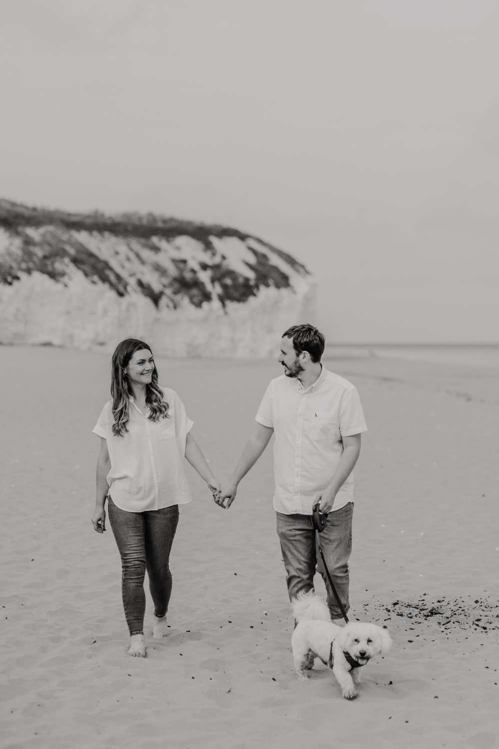 black and white photo as couple pose together with their dog for their kent couple shoot