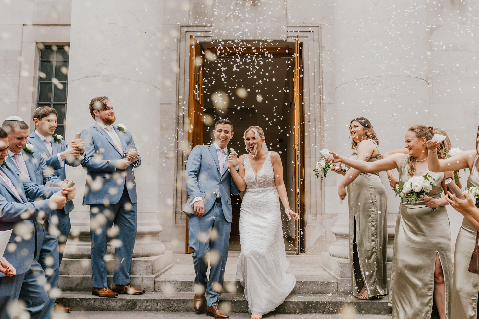 bride and groom confetti moment with bridal party
