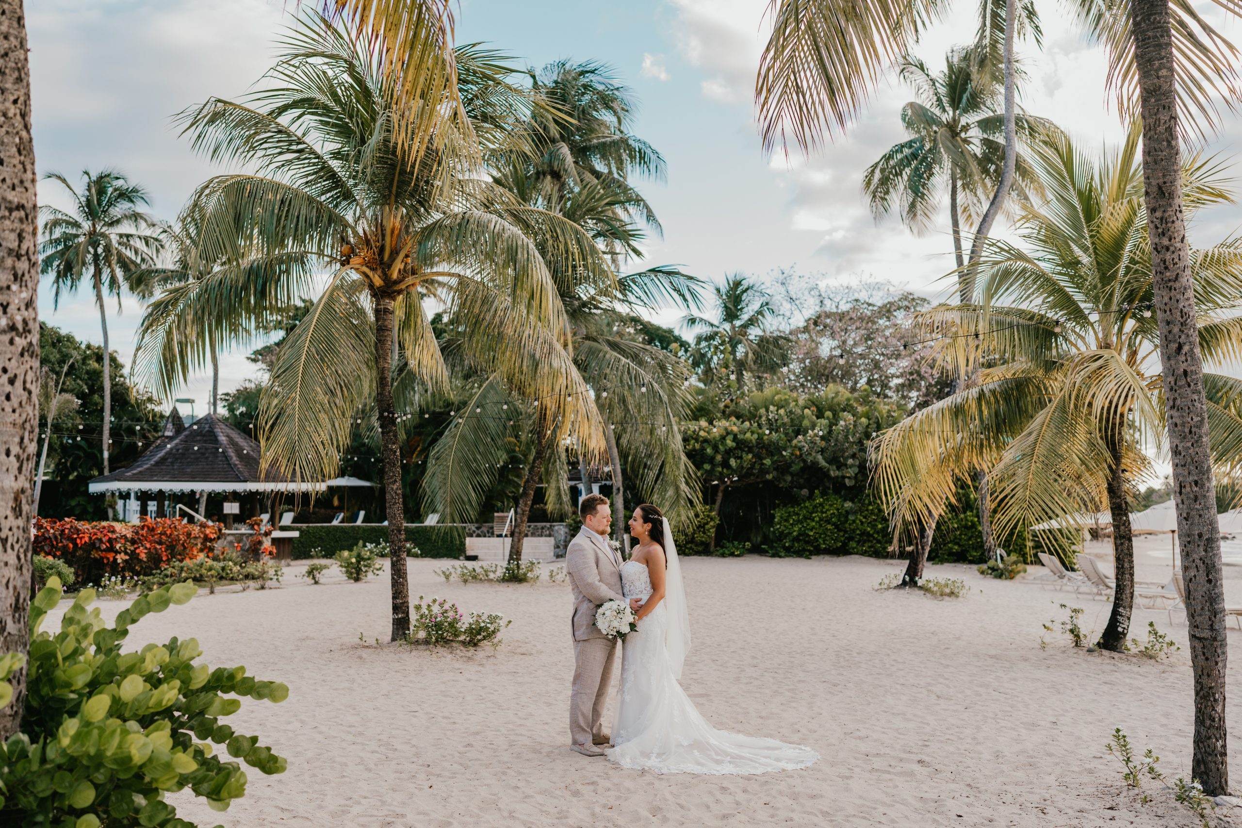 bride and groom surrounded by palm trees on the beach in saint lucia at stolentime by rendezvous wedding venue