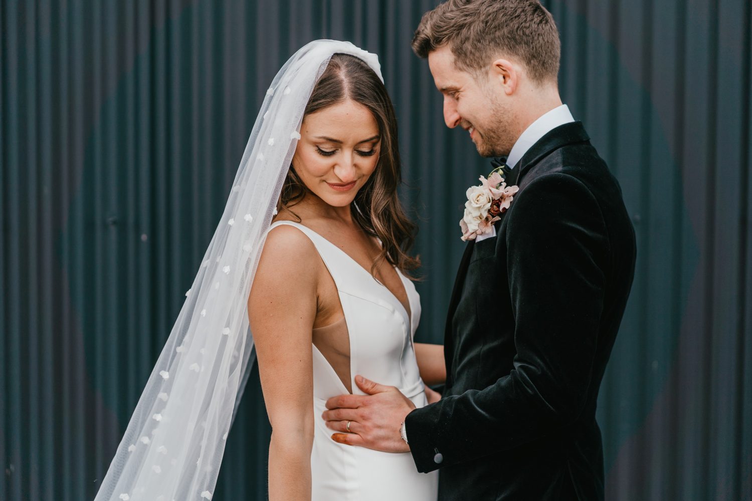 bride and groom couple portraits in front of black steel barn