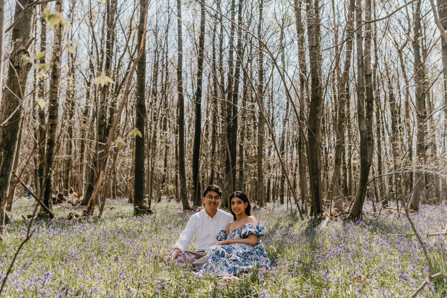 couple sat together in a bluebell woods