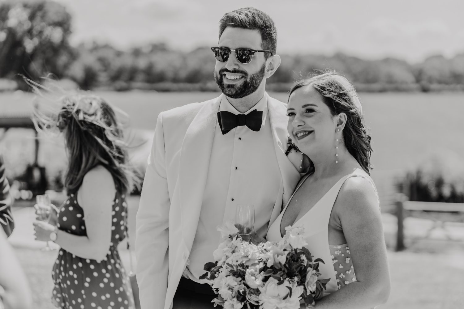 black and white photo of bride and groom posing together on the terrace at botley hill barn wedding venue in surrey