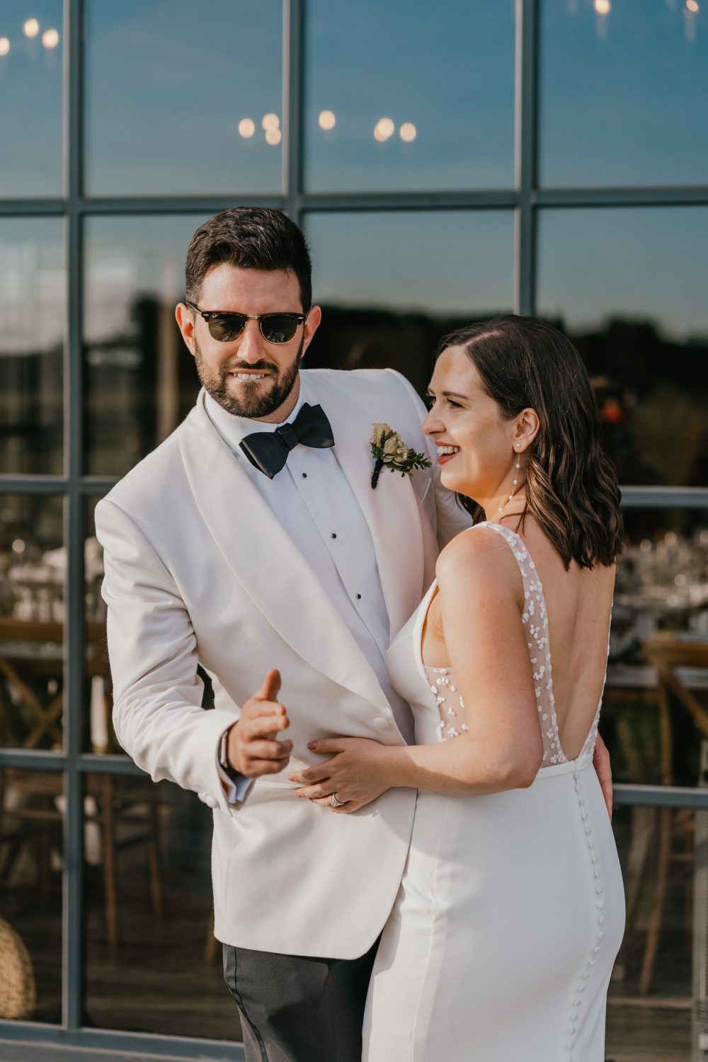 bride and groom stood in front of the main barn's glass front at botley hill barn wedding