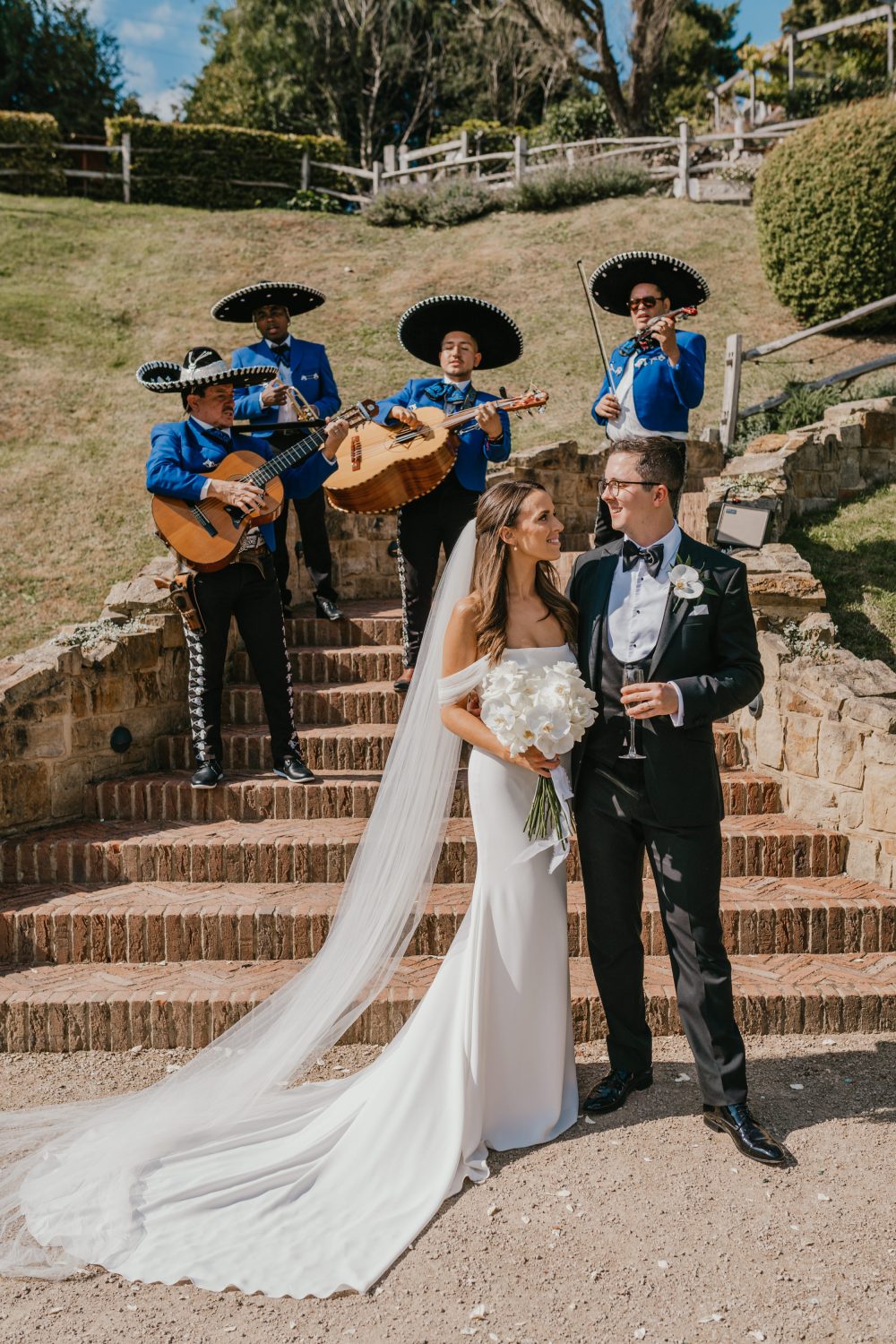 bride and groom pose with mariachi band at the beacon tunbridge wells