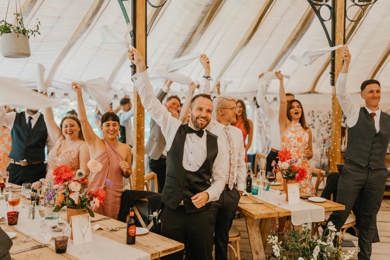 guests wave napkins as bride and groom enter their wedding breakfast at the beacon tunbridge wells