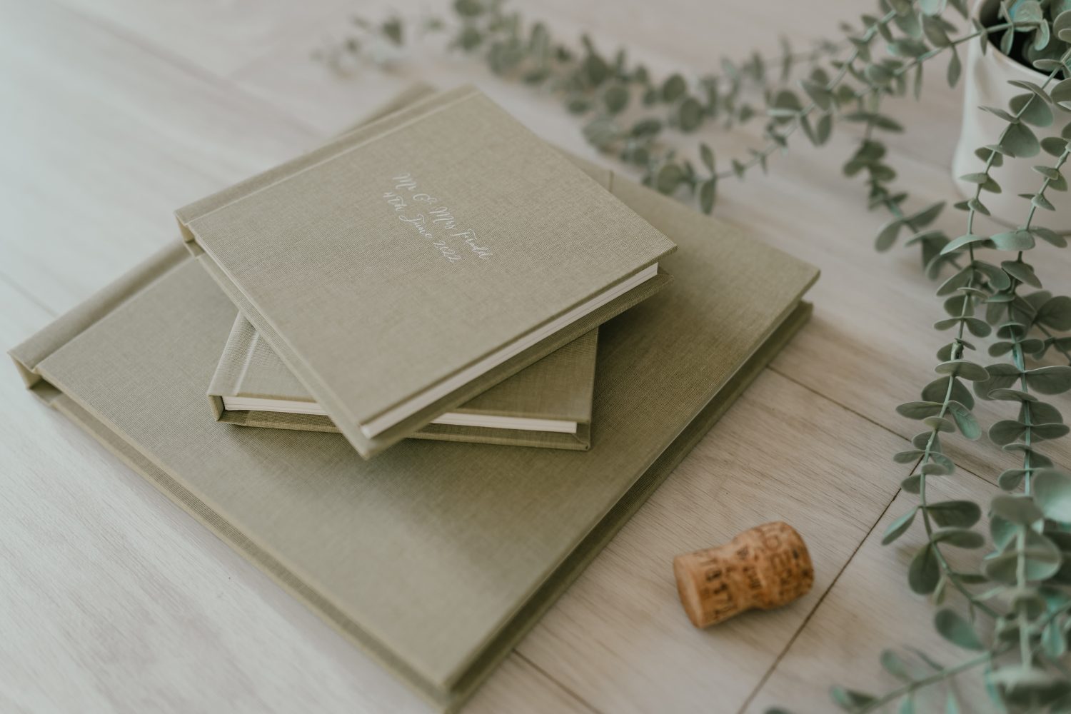 stack of green wedding albums