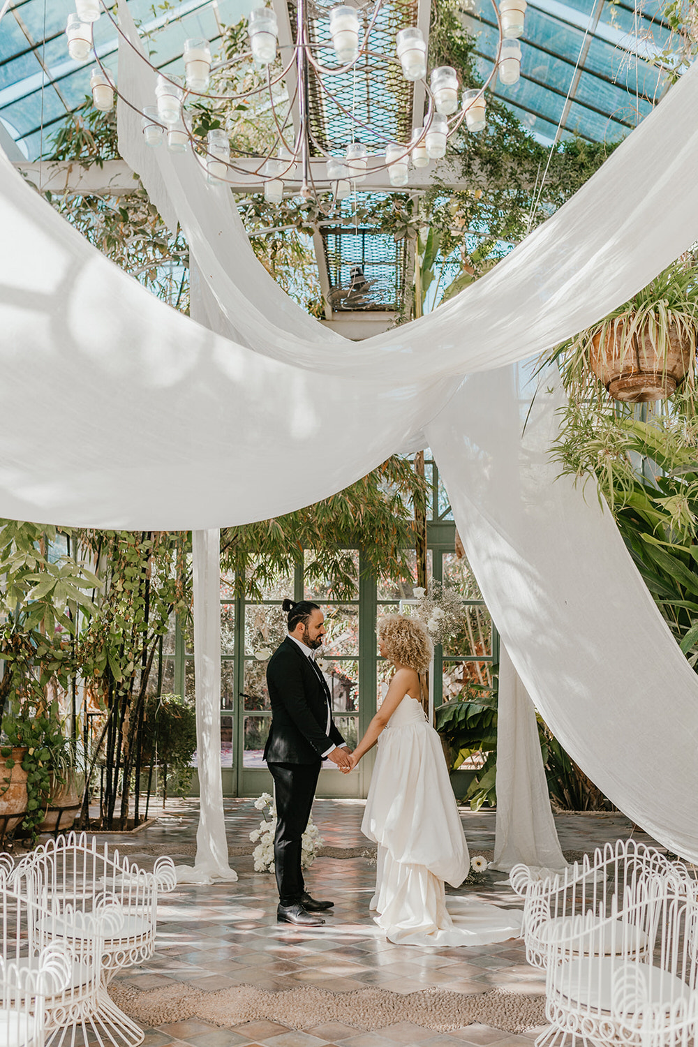 bride and groom stood at the altar at beldi club glasshouse wedding ceremony