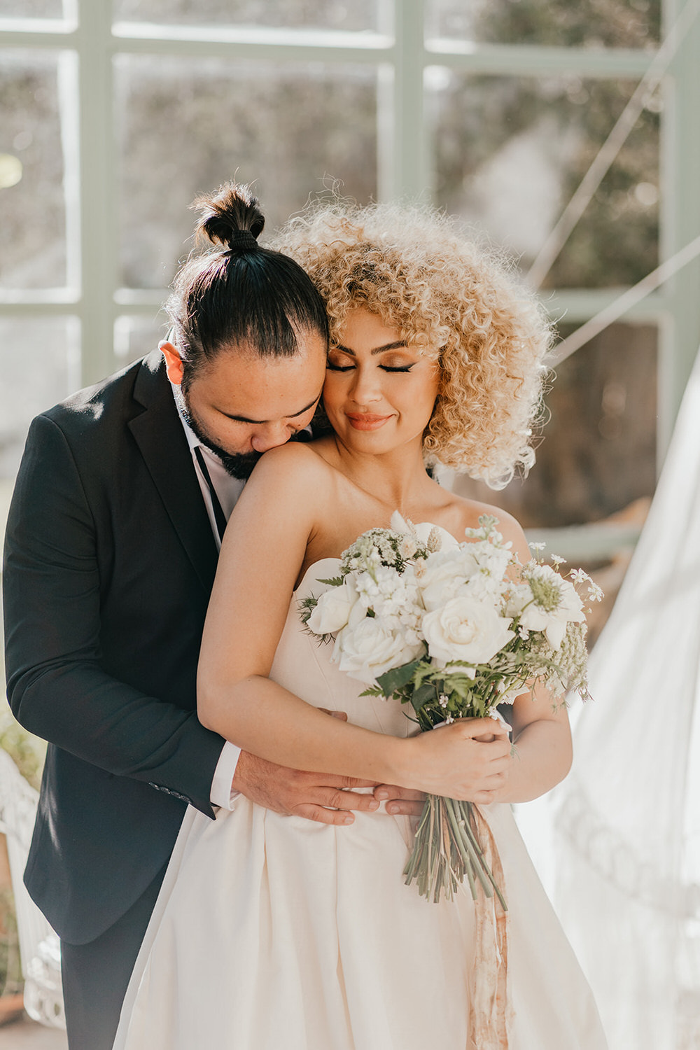 bride and groom embrace in golden hour light in the greenhouse at beldi country club in marrakech