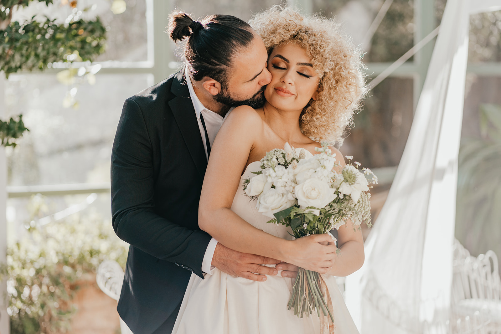 bride and groom embrace in golden hour light in the greenhouse at beldi country club in marrakech