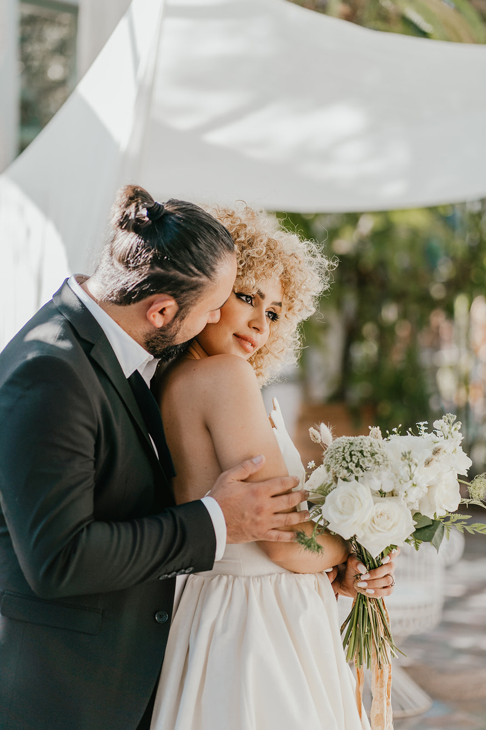 bride and groom embrace in golden hour light in the greenhouse at beldi country club in marrakech