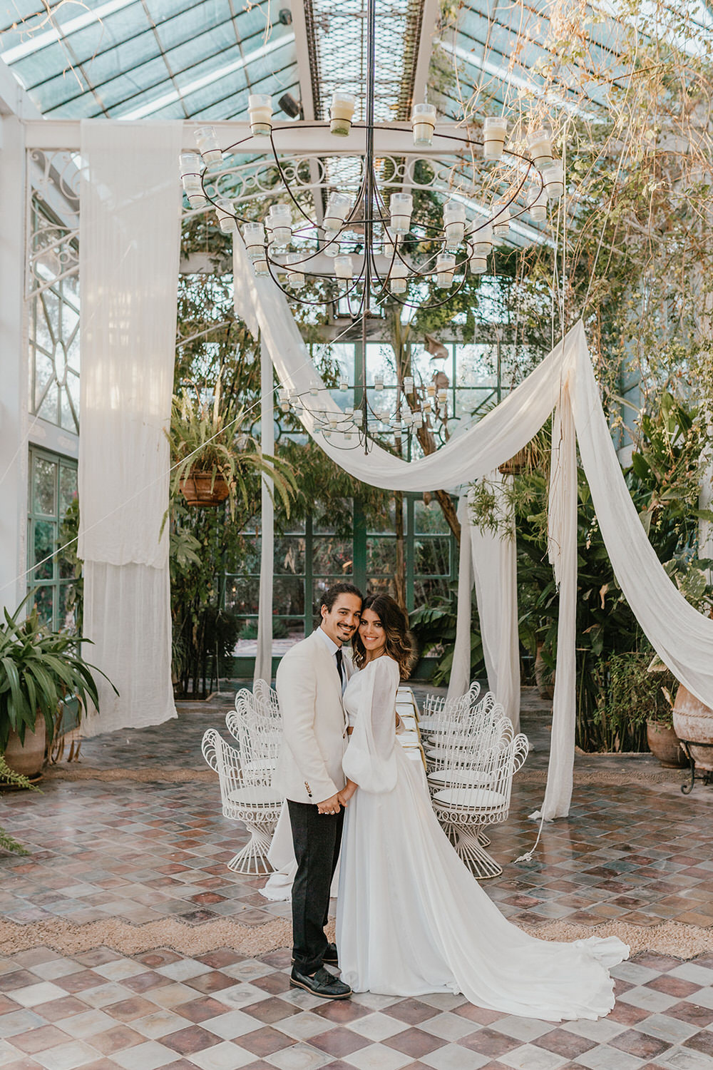 bride and groom pose in glasshouse at beldi country club wedding marrakech