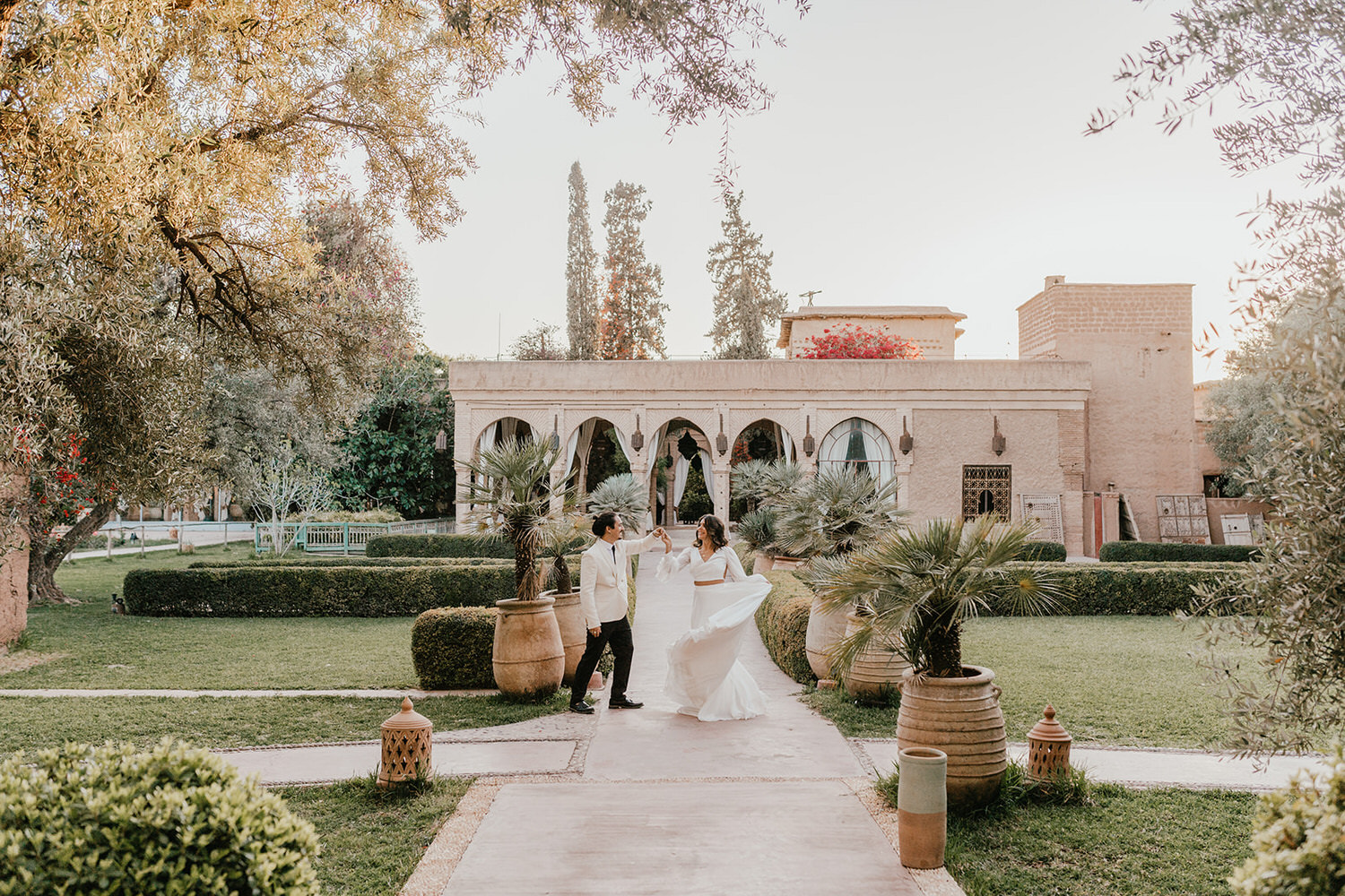 bride and groom dance in the gardens at beldi country club wedding venue in morocco
