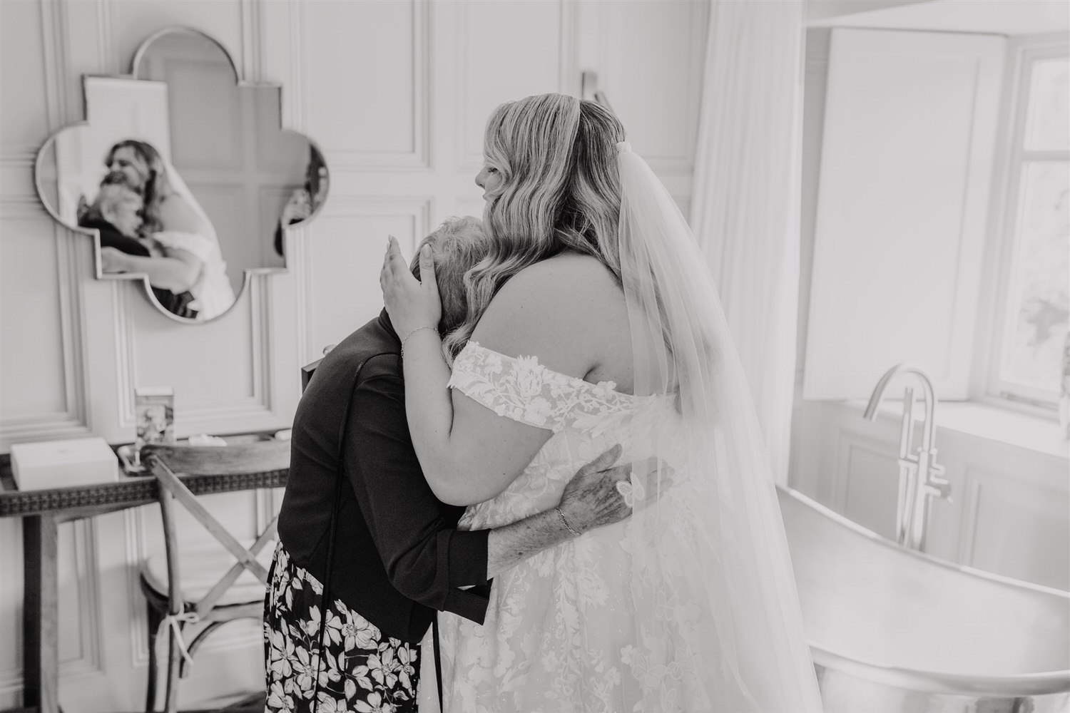 black and white photo of bride hugging grandma at chapel house estate wedding