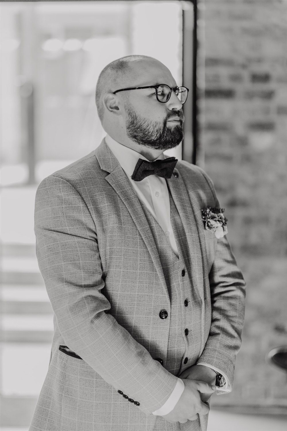 black and white photo of groom waiting for bride before wedding ceremony