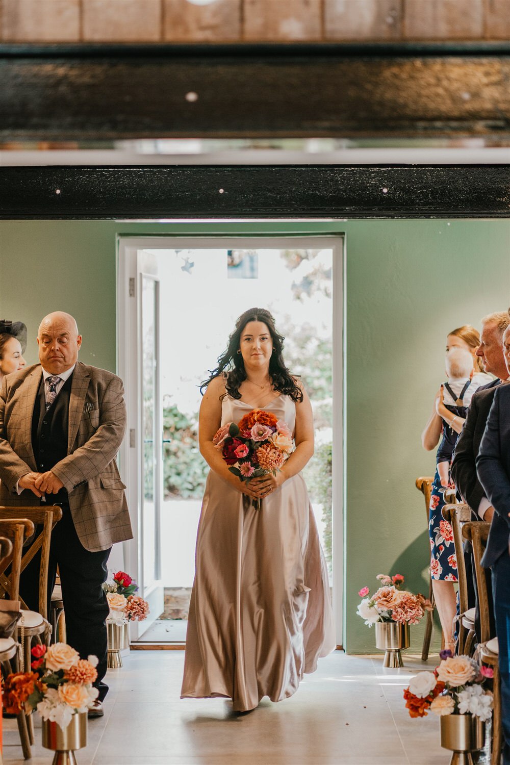 bridesmaid walking down the aisle at chapel house estate wedding