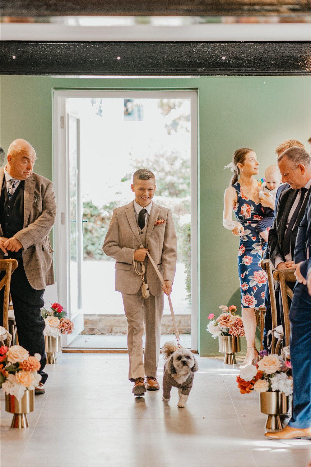 groomsman walking down the aisle with dog at chapel house estate wedding
