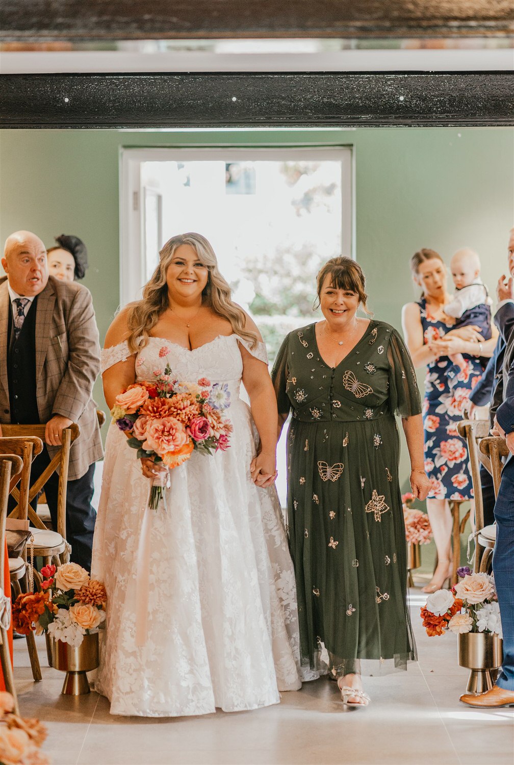 bride walks down the aisle with her mum at chapel house estate wedding