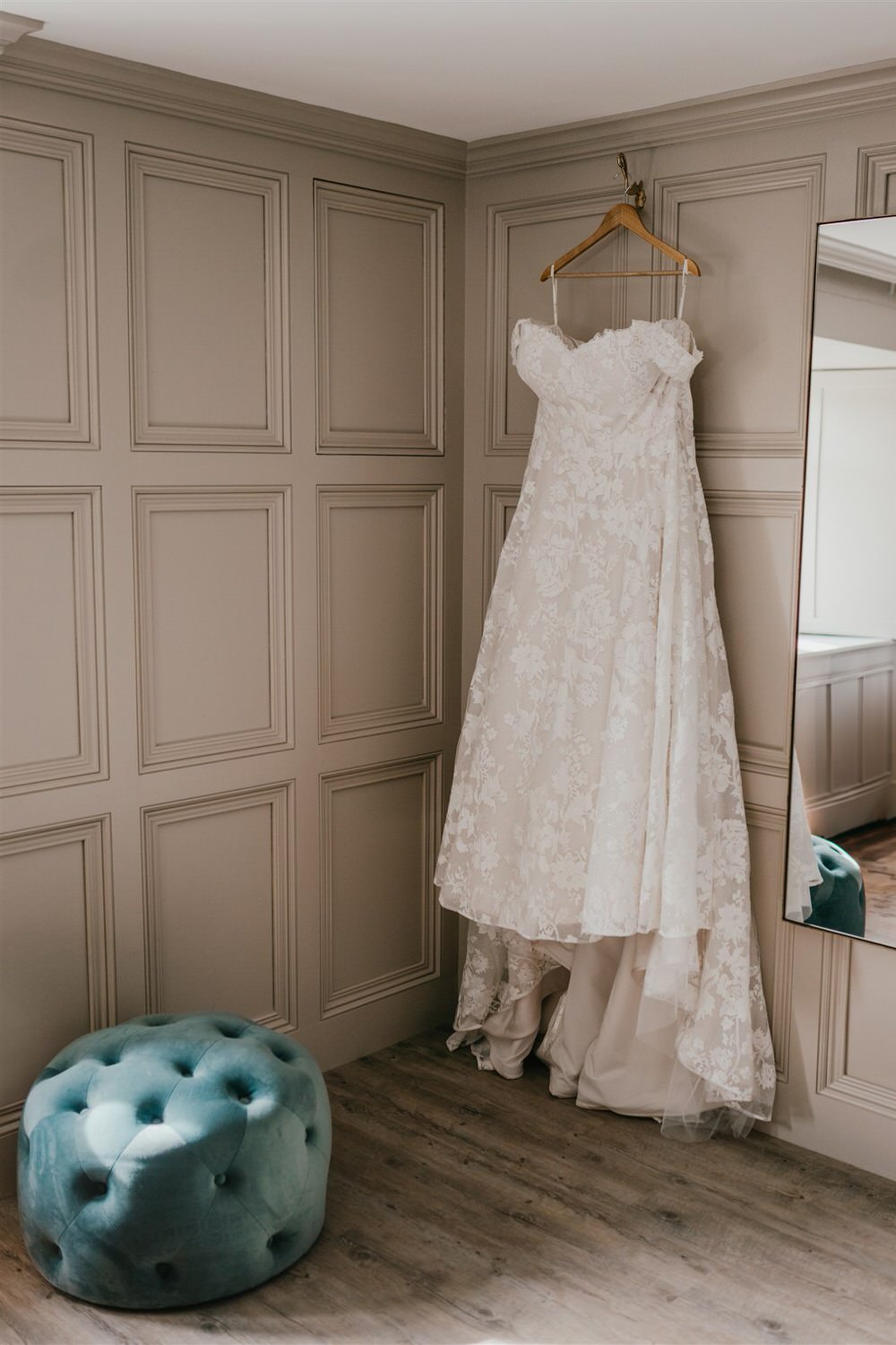 wedding dress hung in the bedroom at chapel house estate wedding venue in kent
