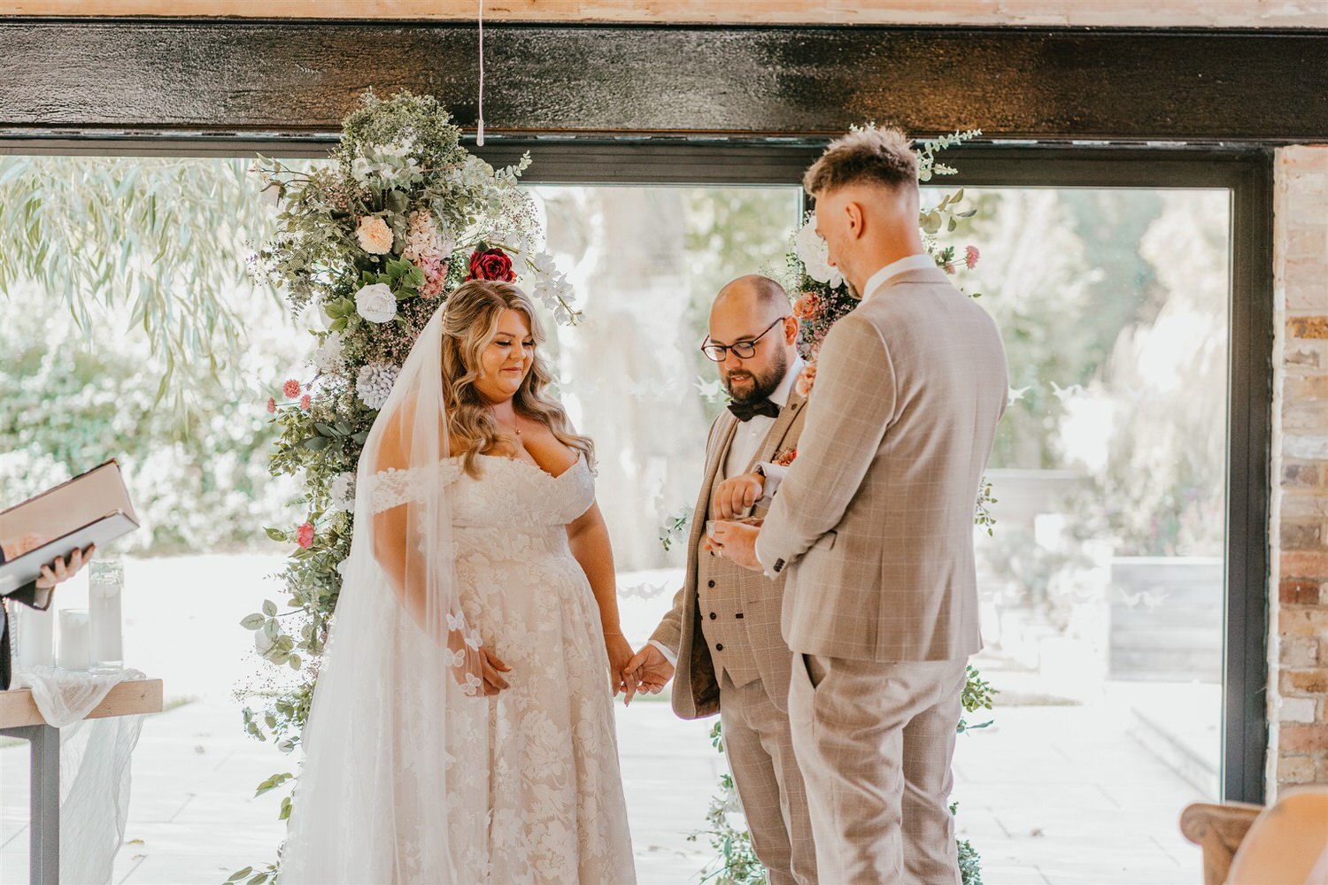 bride and groom exchange rings at chapel house estate wedding in kent
