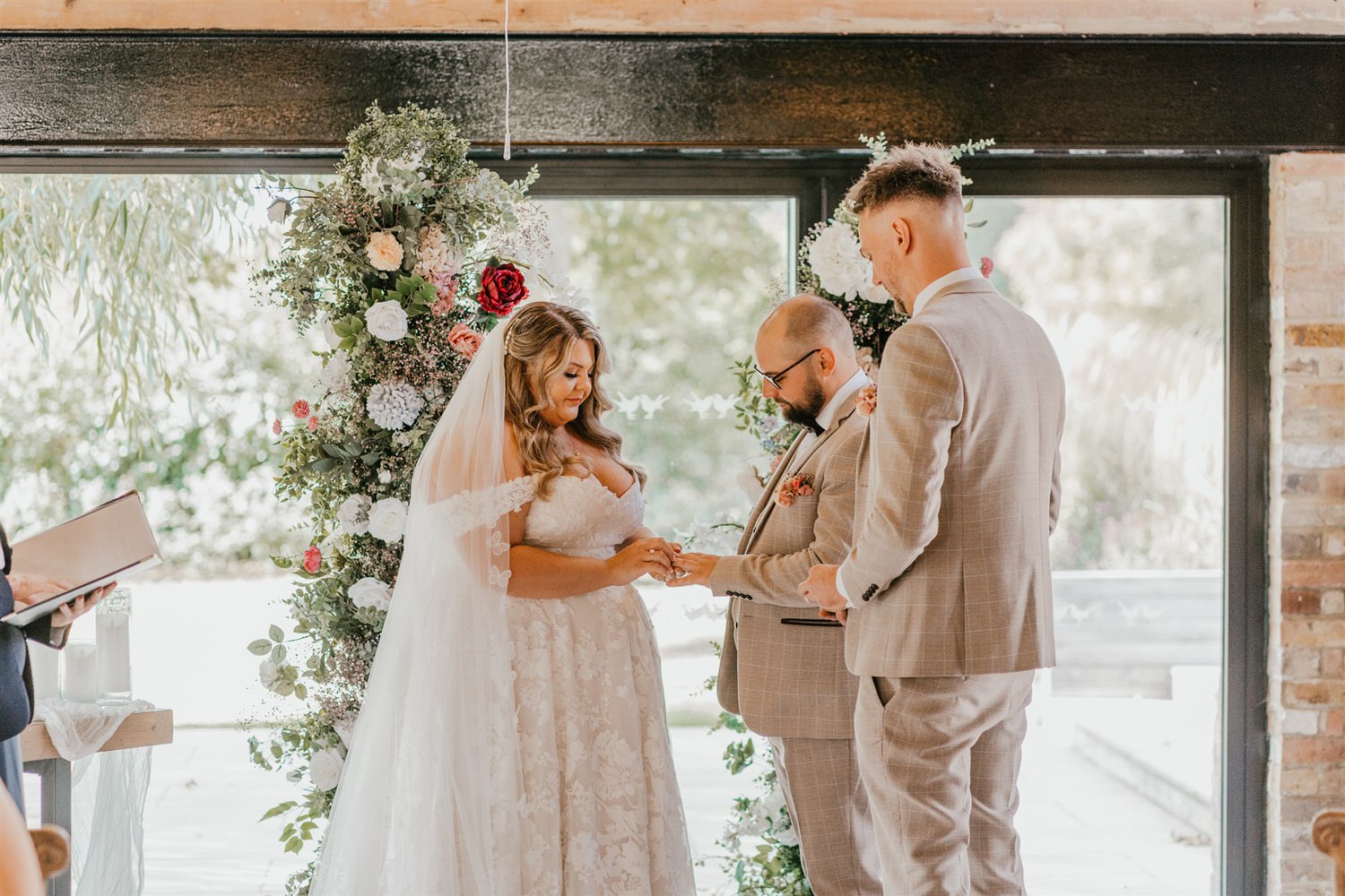 bride and groom exchange rings at chapel house estate wedding in kent