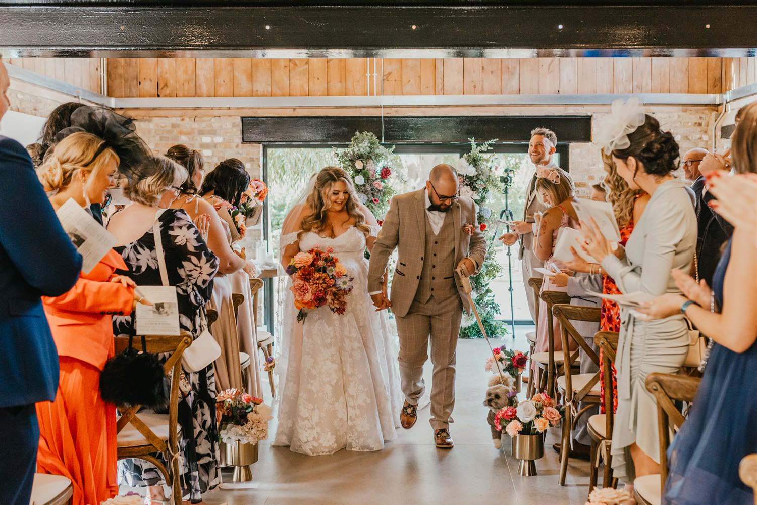 bride and groom walk back up the aisle after wedding ceremony at chapel house estate wedding venue in kent