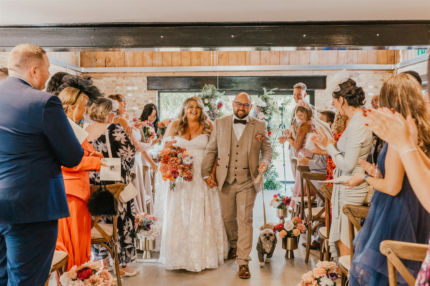 bride and groom walk back up the aisle after wedding ceremony at chapel house estate wedding venue in kent