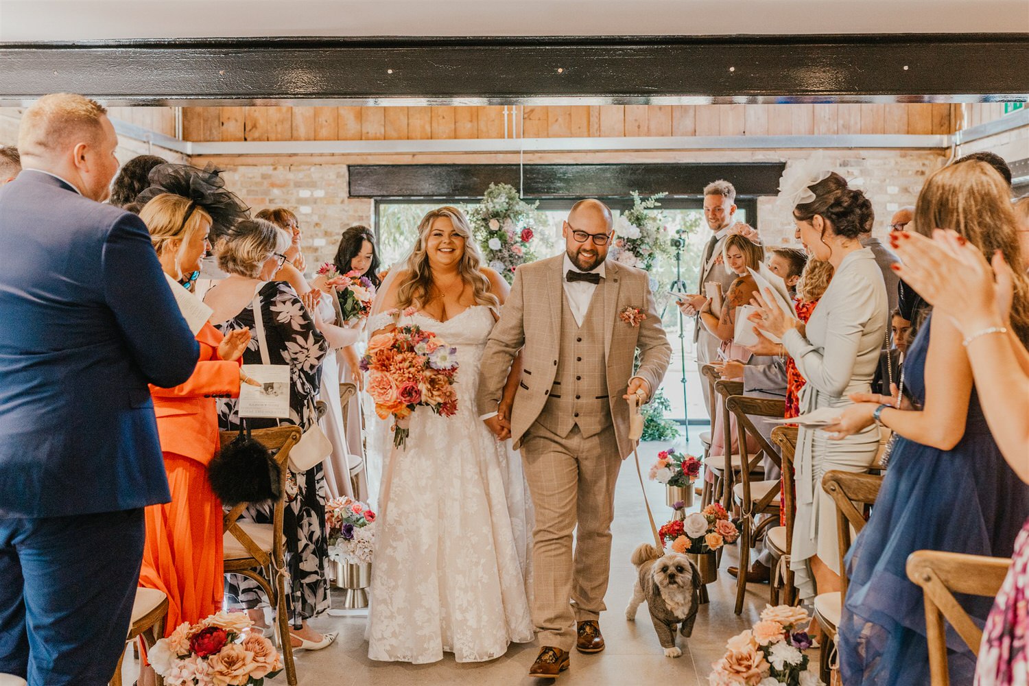 bride and groom walk back up the aisle after wedding ceremony at chapel house estate wedding venue in kent