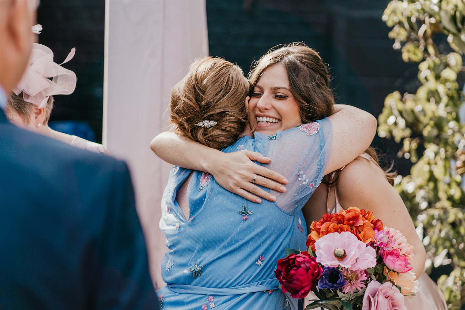 guests hugging during drinks reception in the courtyard at chapel house estate wedding venue in kent