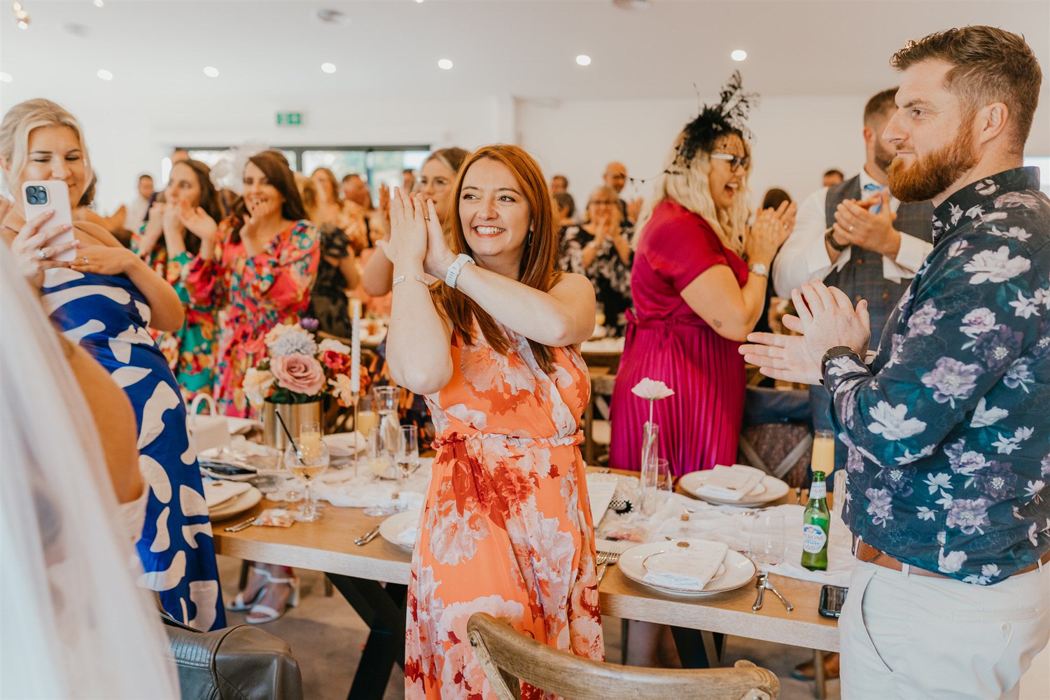 guests clap during bride and groom entrance into wedding breakfast at chapel house estate
