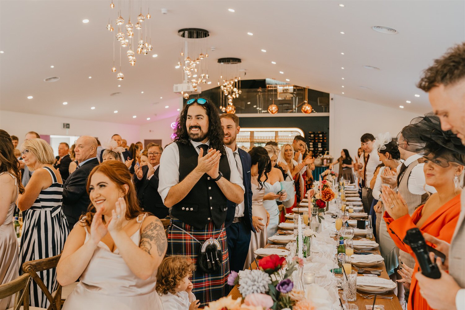 guests clap during bride and groom entrance into wedding breakfast at chapel house estate
