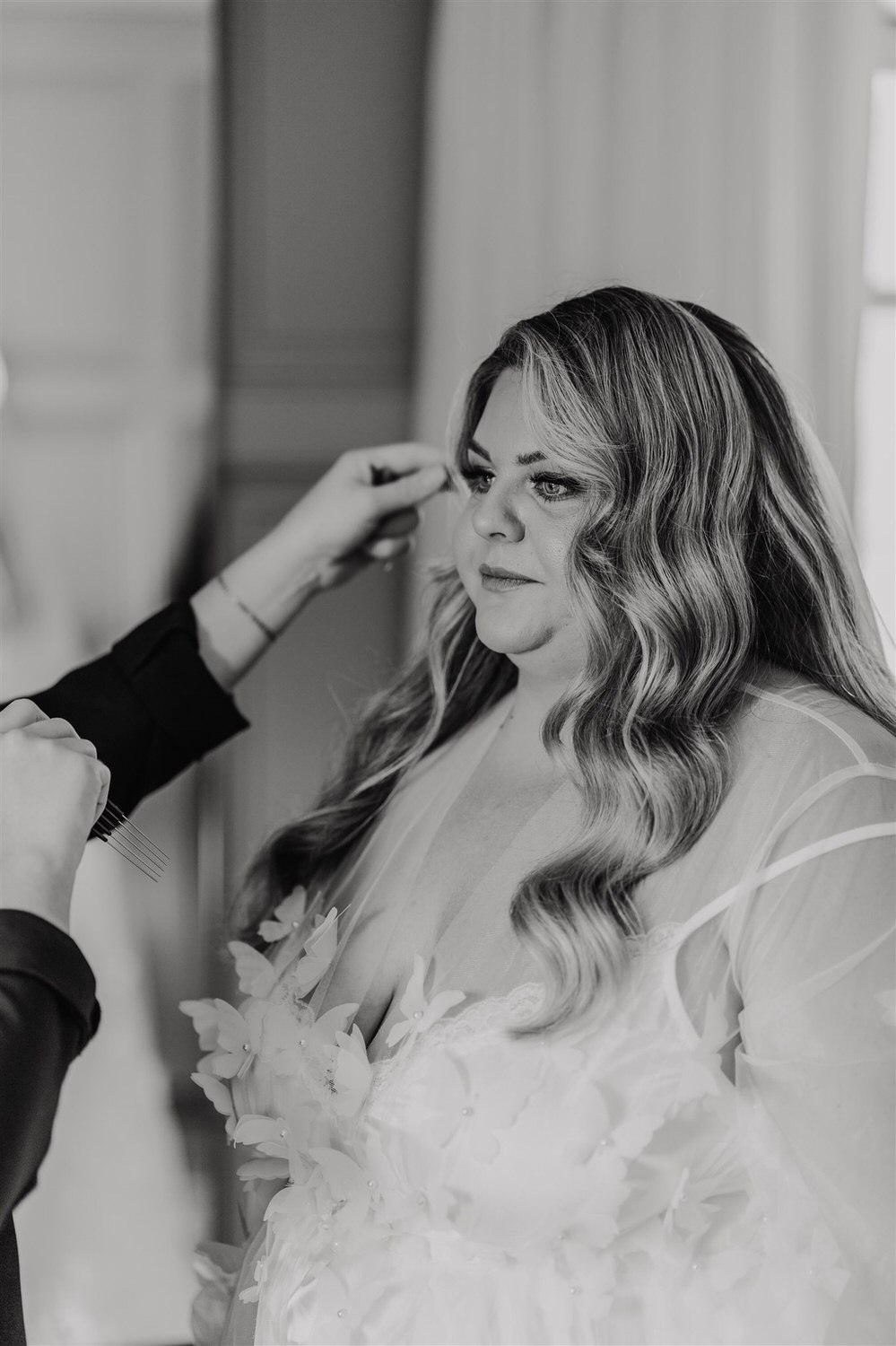 black and white photo of bride having final touch ups during bridal prep at chapel house estate wedding