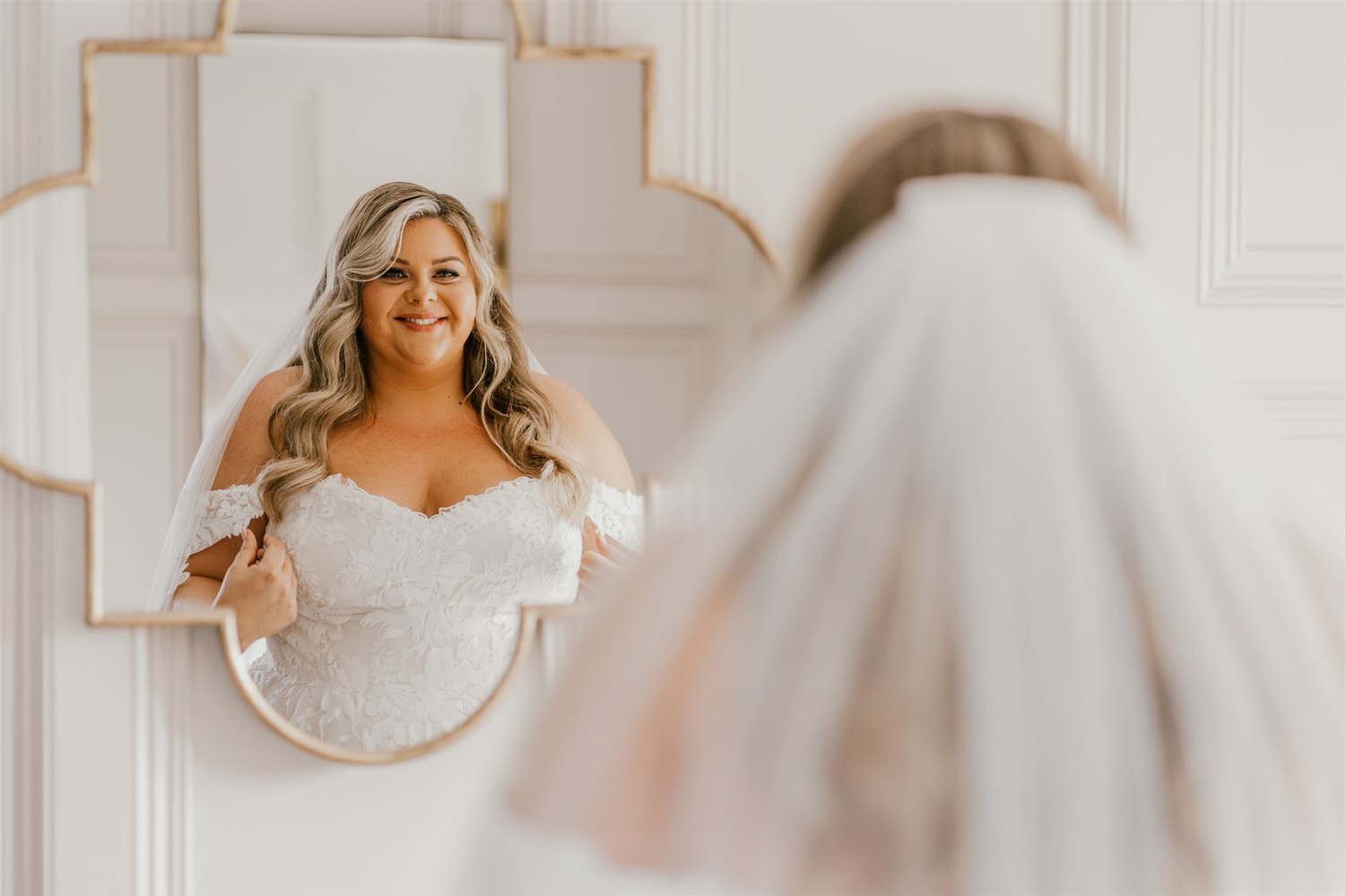 bride looking in the mirror during bridal prep at chapel house estate wedding