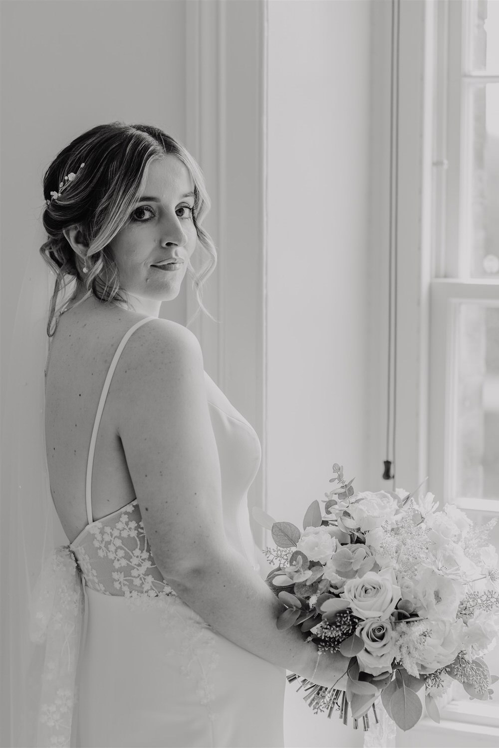black and white portrait of bride in her wedding dress holding bouquet