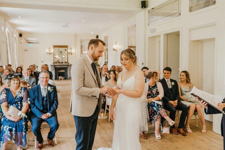 bride and groom exchange rings during wedding ceremony at hotel du vin tunbridge wells