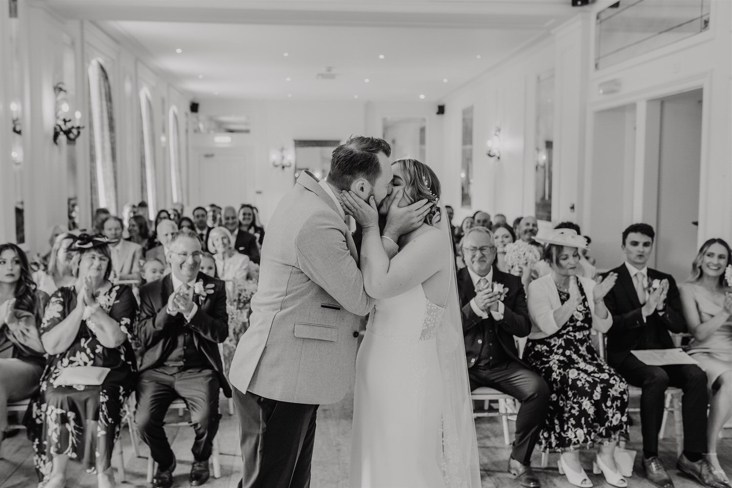 black and white photo of bride and groom first kiss at hotel du vin tunbridge wells wedding ceremony