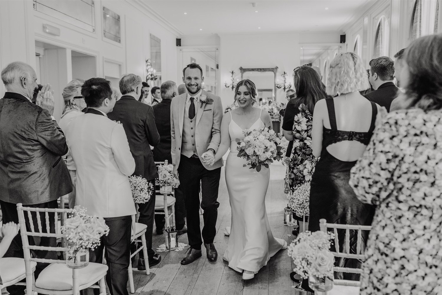 black and white photo of bride and groom walking back up the aisle at hotel du vin wedding ceremony