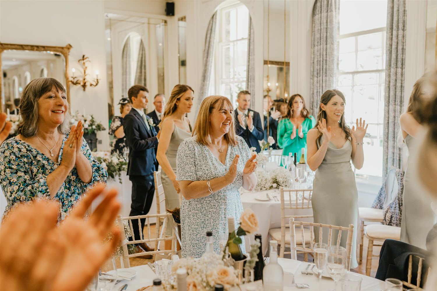 guests applaud for bride and groom entrance in the ballroom at hotel du vin tunbridge wells wedding