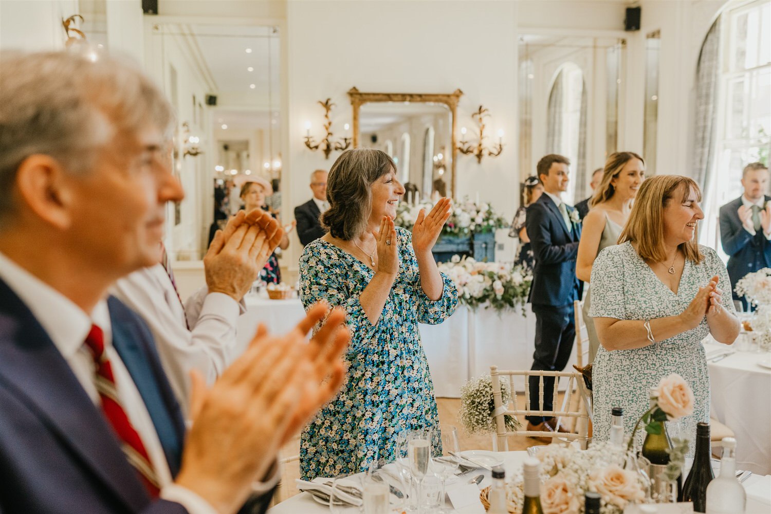 guests applaud for bride and groom entrance in the ballroom at hotel du vin tunbridge wells wedding