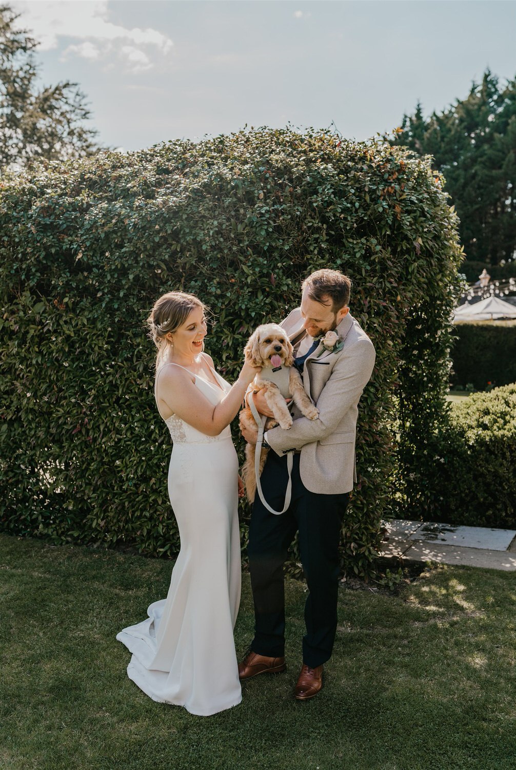 bride and groom hold their dog during portraits at hotel du vin tunbridge wells wedding