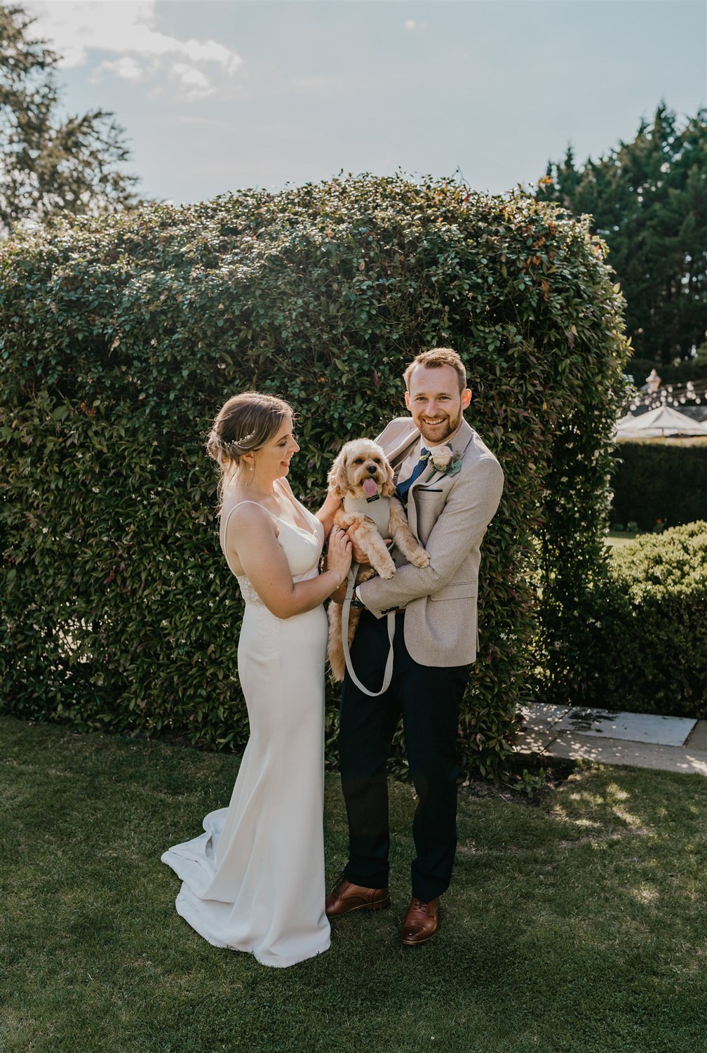 bride and groom hold their dog during portraits at hotel du vin tunbridge wells wedding