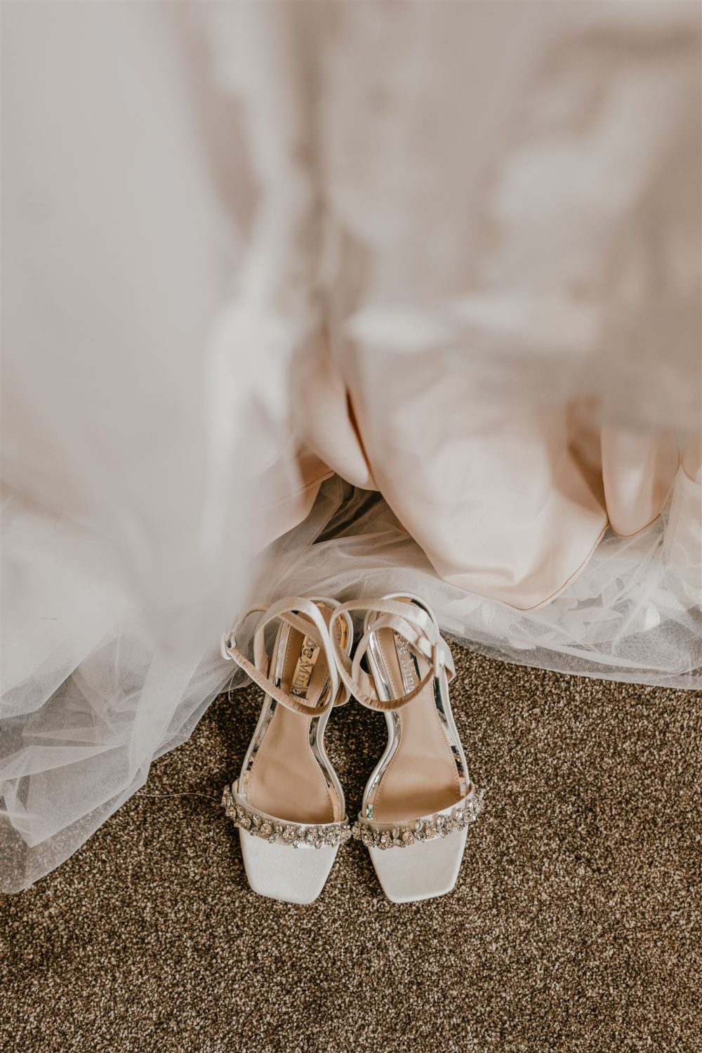 bride's shoes beneath the wedding dress skirt