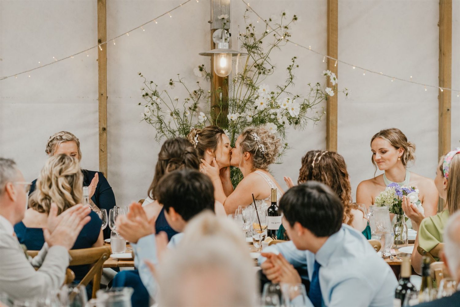 brides share a kiss after wedding speeches