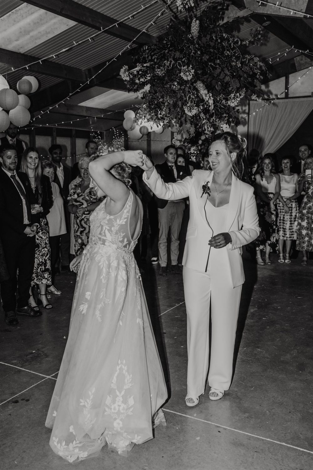 black and white photo of two brides having their first dance at diy wedding venue acorn barn in oxfordshire