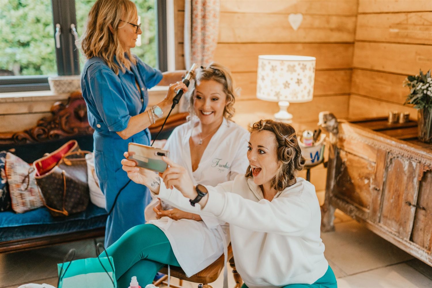 bridesmaid poses for funny selfie with bride on her wedding morning