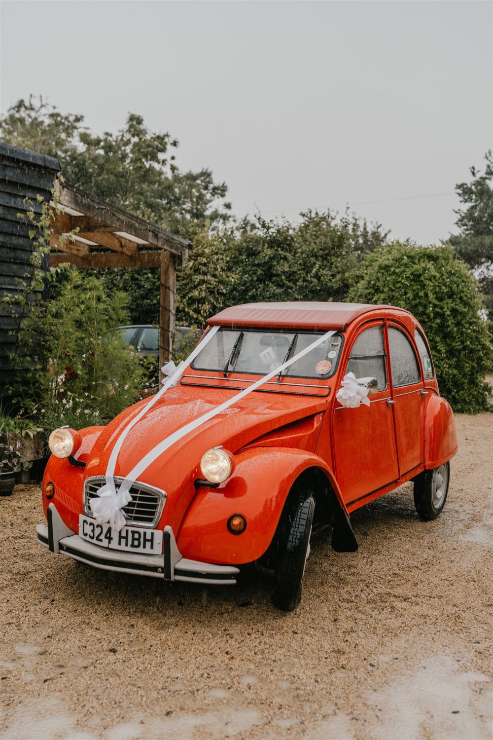 vintage red wedding car arriving at acorn barn wedding venue