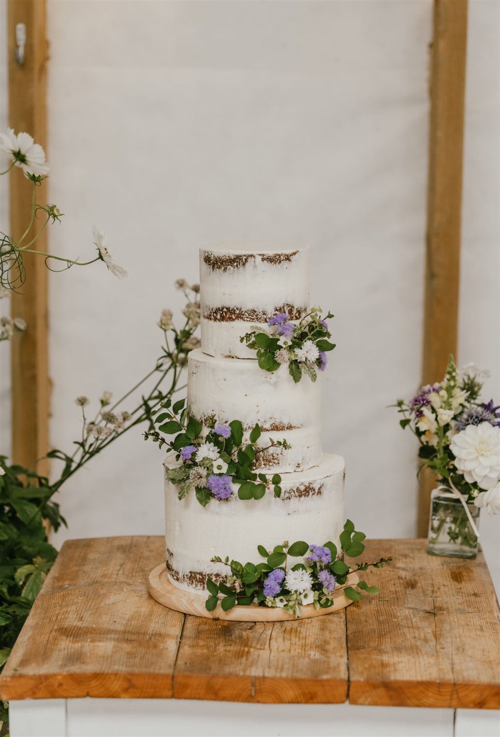 wedding cake setup on wooden table at acorn barn wedding
