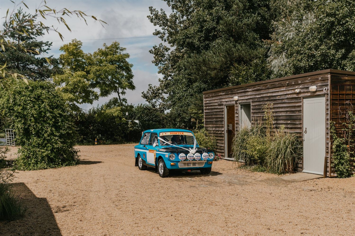bride arrives in dad's rally car at acorn barn wedding venue in oxfordshire
