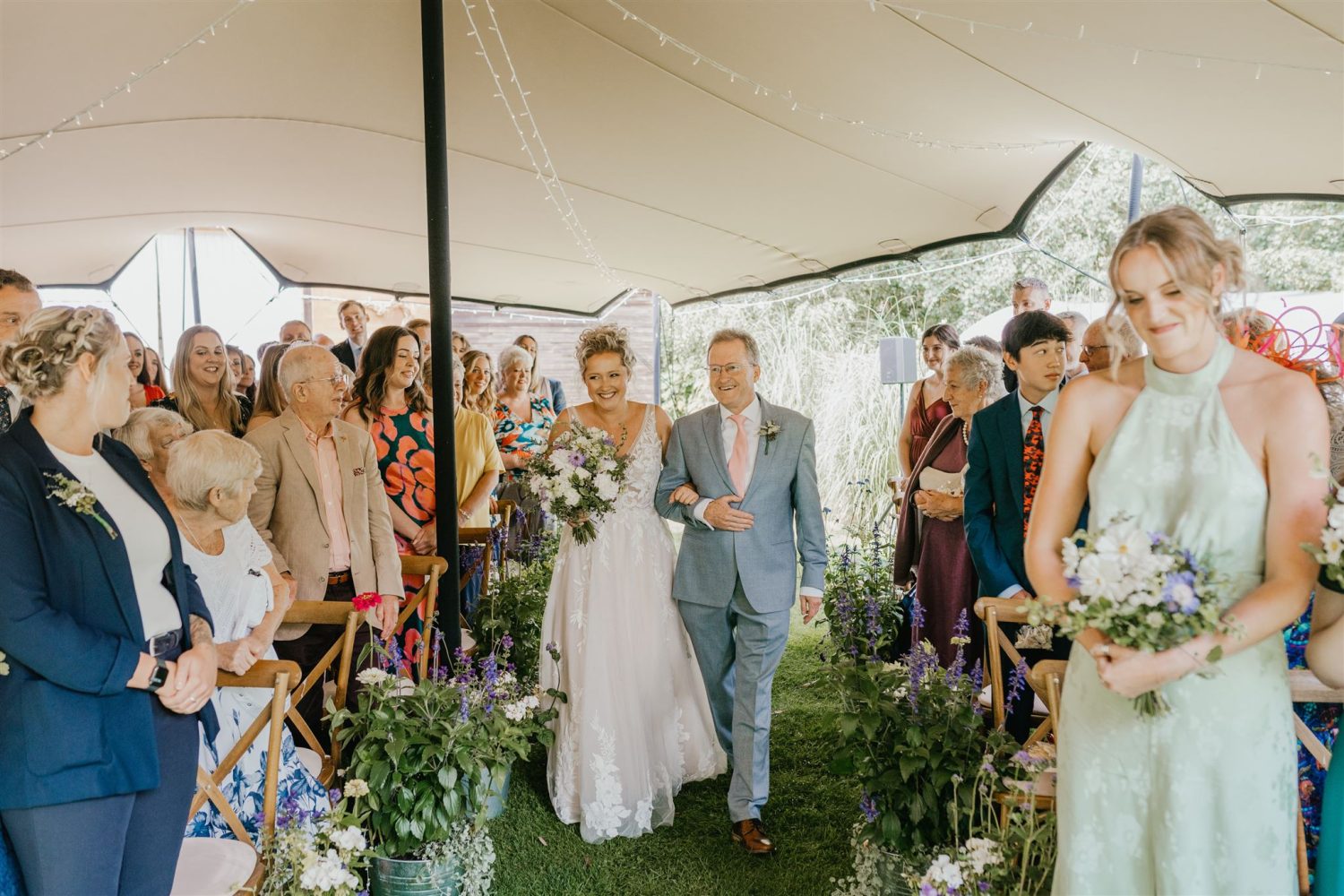 bride walks down the aisle with father at acorn barn wedding ceremony